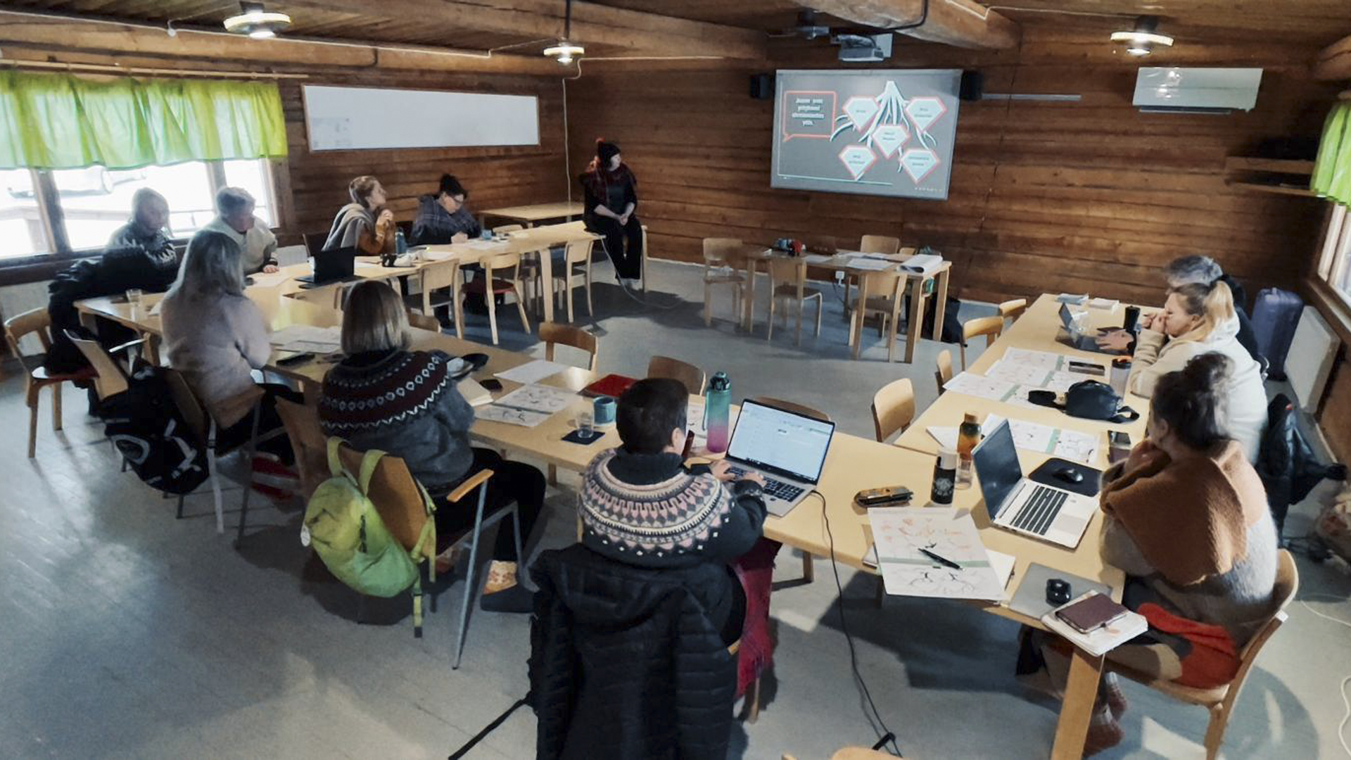 Tarinallistamisvalmennuksen väki kuvattuna takaa, tarinallistaja Anne Kalliomäki kertoo osallistujien etupuolella kuinka merkityksellinen tarina luodaan.